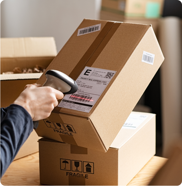 Hands scanning barcode on delivery parcel. Worker scan barcode of cardboard packages before delivery at storage. Woman working in factory warehouse scanning labels on the boxes with barcode scanner.